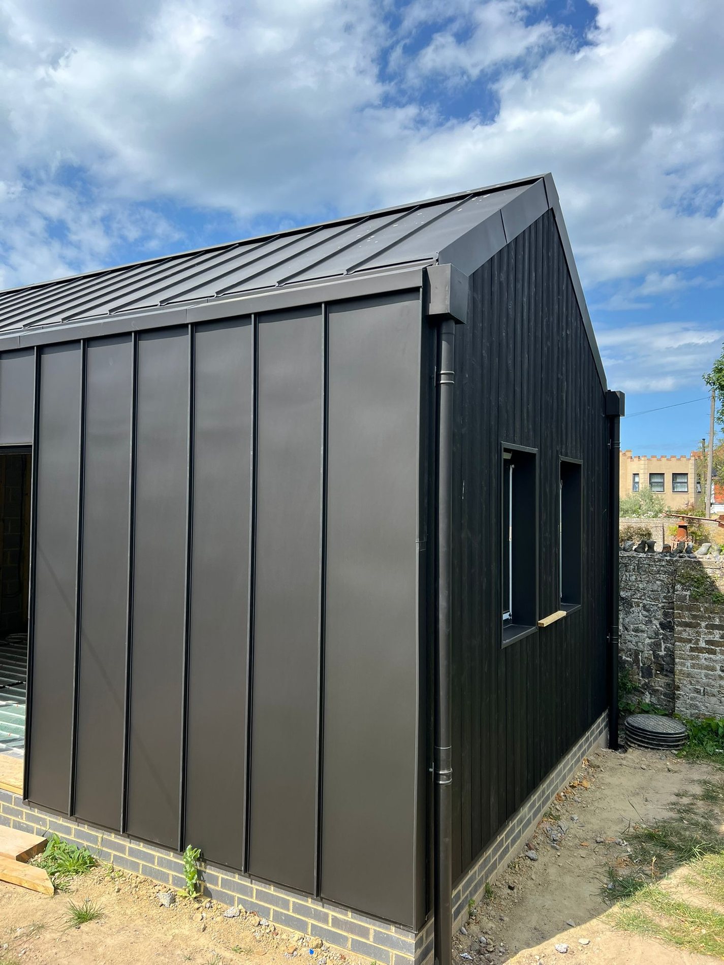 Black zinc garden pavilion. Anthra roof and cladding with a concealed gutter and flush window reveals